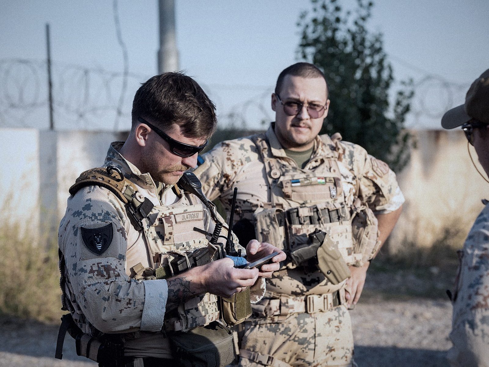 Militares consultando un terminal móvil durante un ejercicio en campo